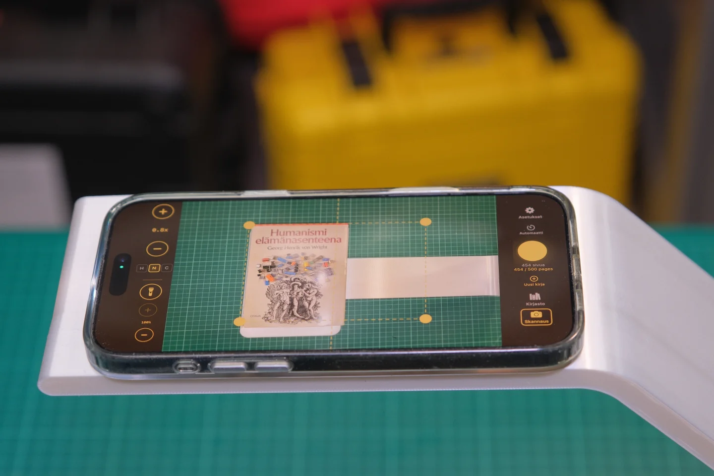 Knut eskaneatzeko euskarria iPhonea muntatuta duela, liburu ireki bat eskaneatzen